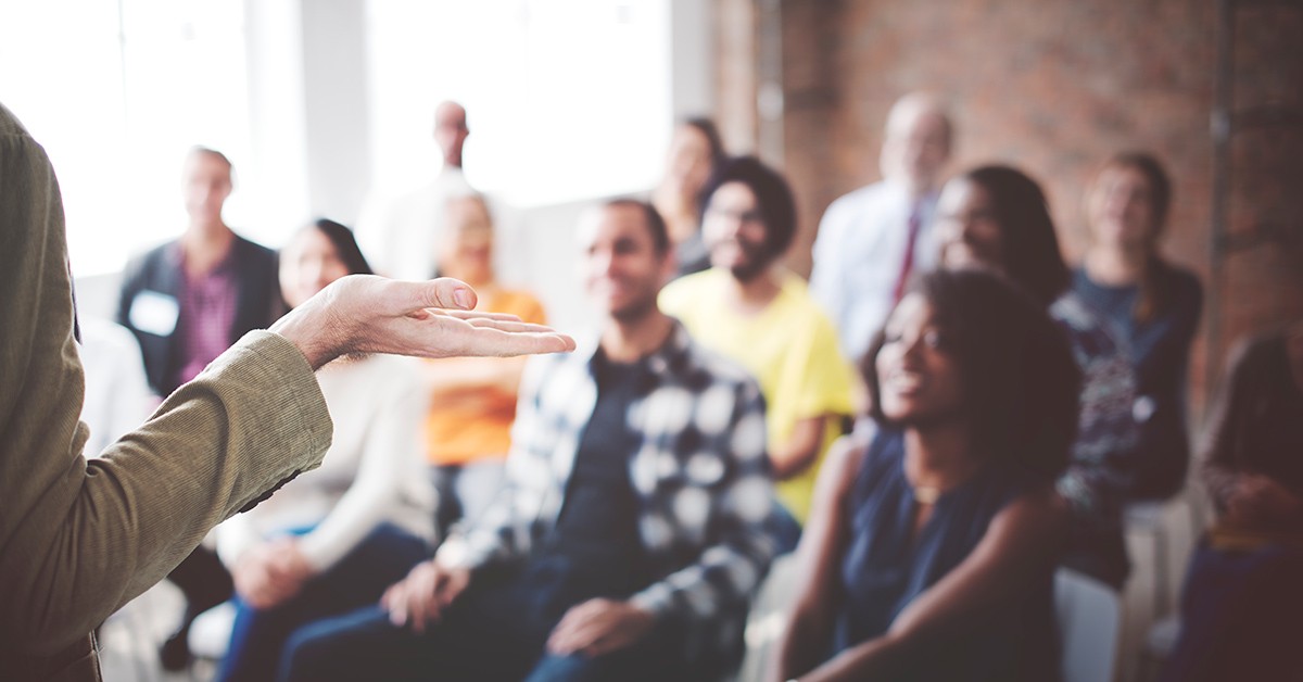 Onscherpe foto van groep mensen die naar een lezing luisteren